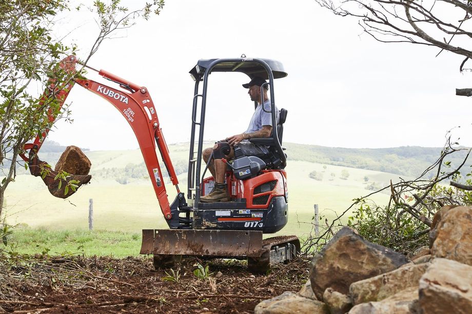 Landscaper Using a Mini Excavator To Move Rocks — Hinterland Property Services in Coopers Shoot, NSW