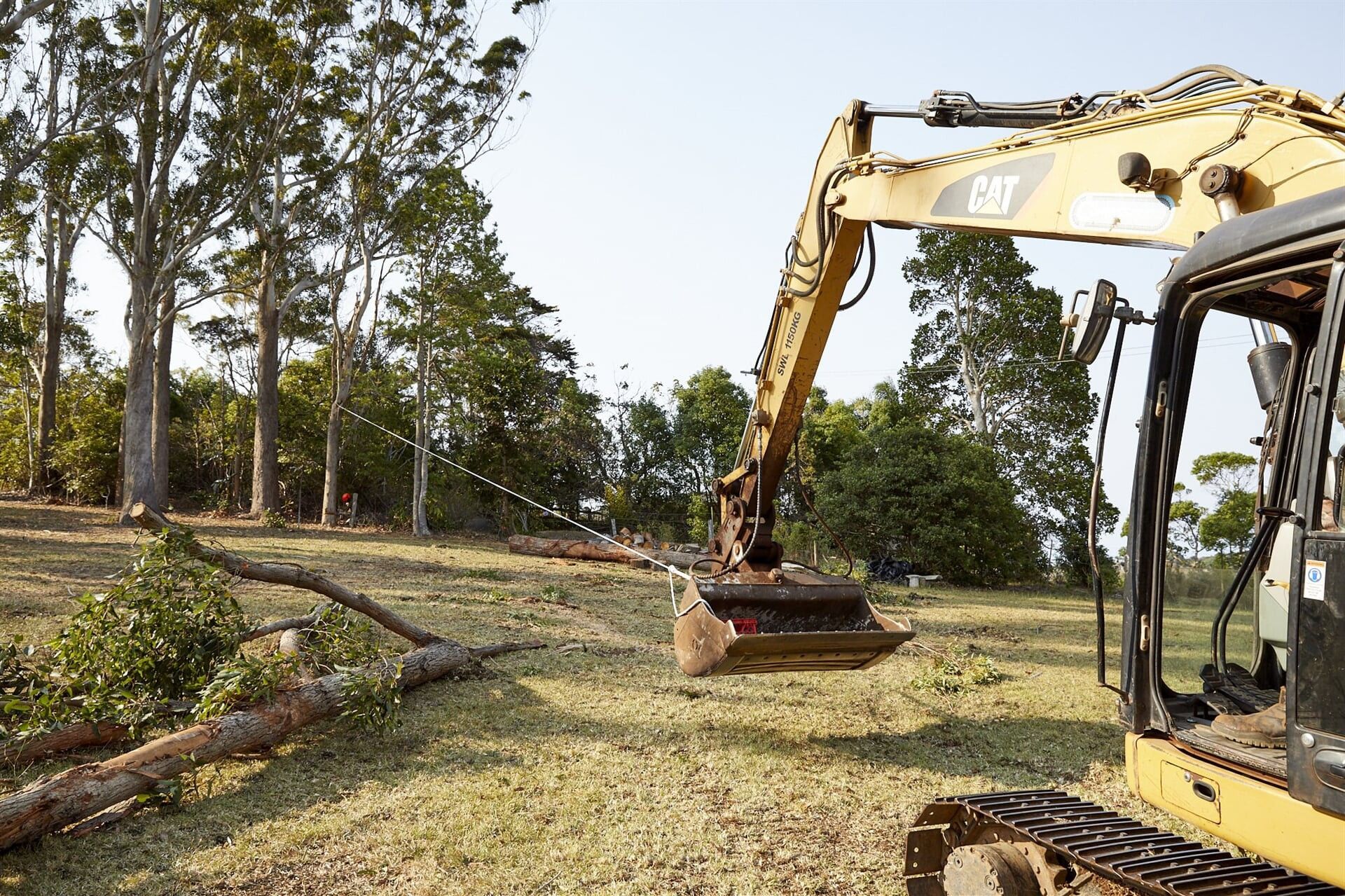 Excavator Using a Rope to Pull Down a Tree — Hinterland Property Services in Coopers Shoot, NSW
