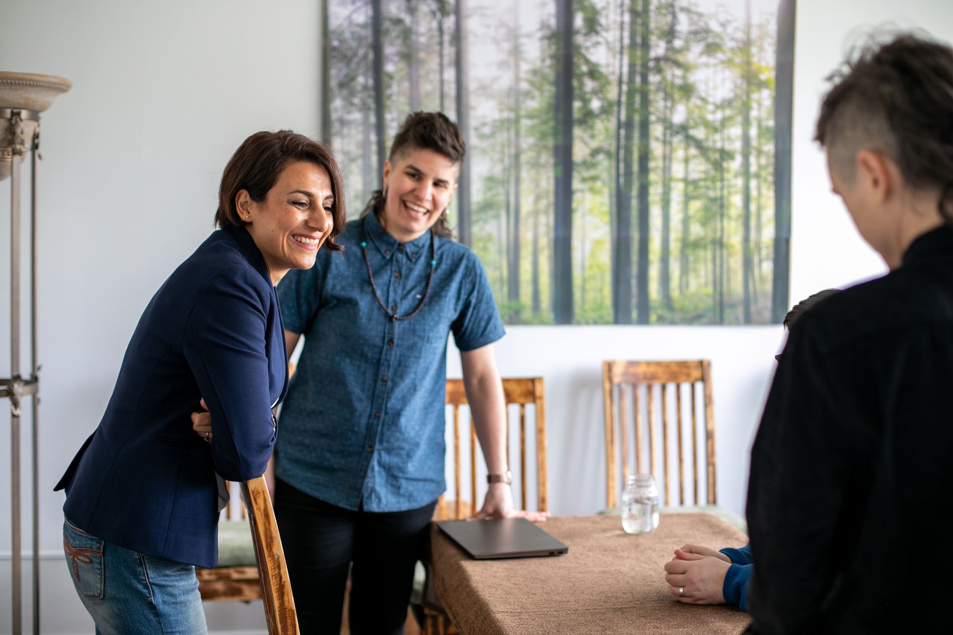 A couple of people standing next to each other at a table.