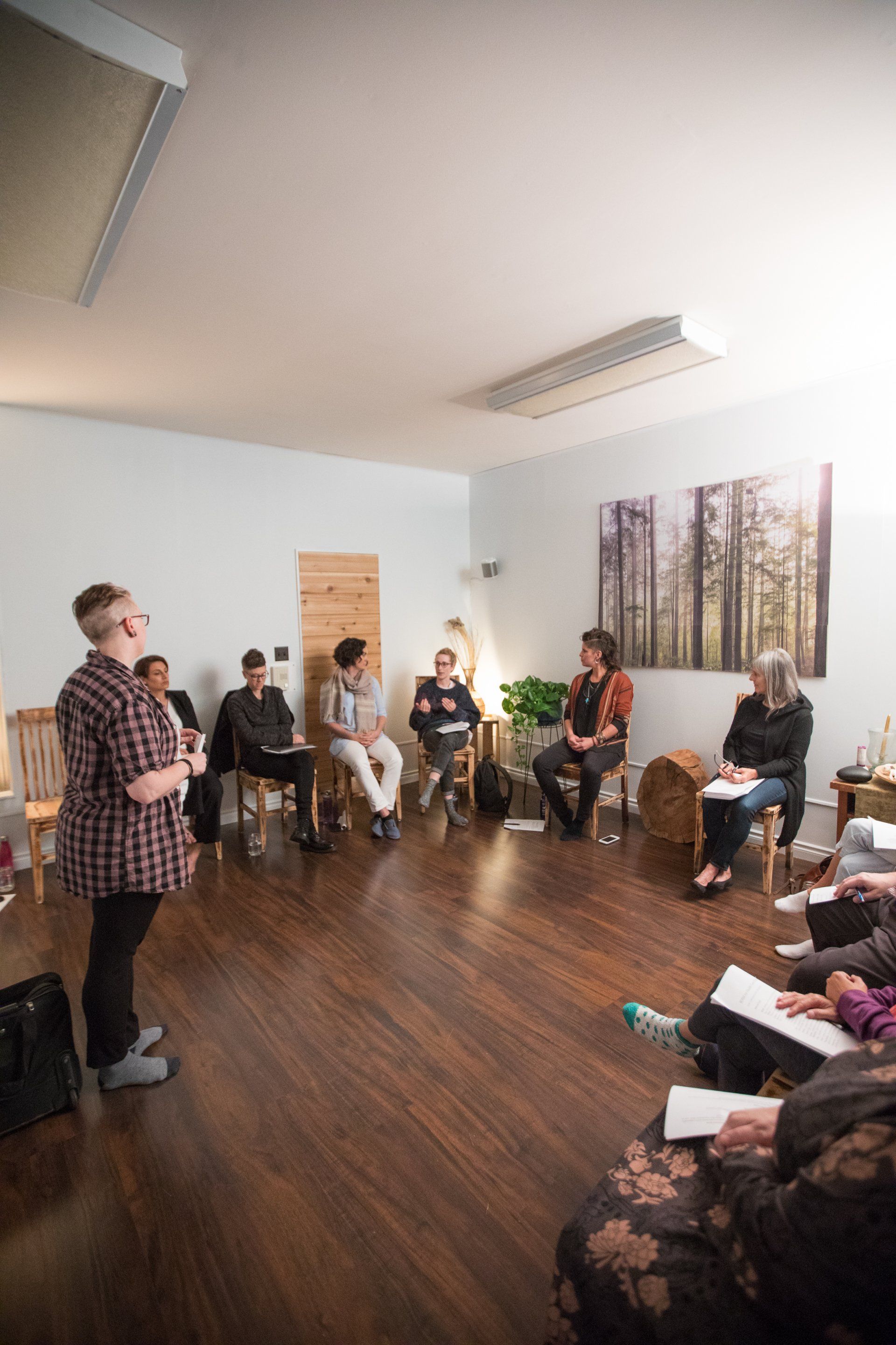 A group of people are sitting in a circle in a room.