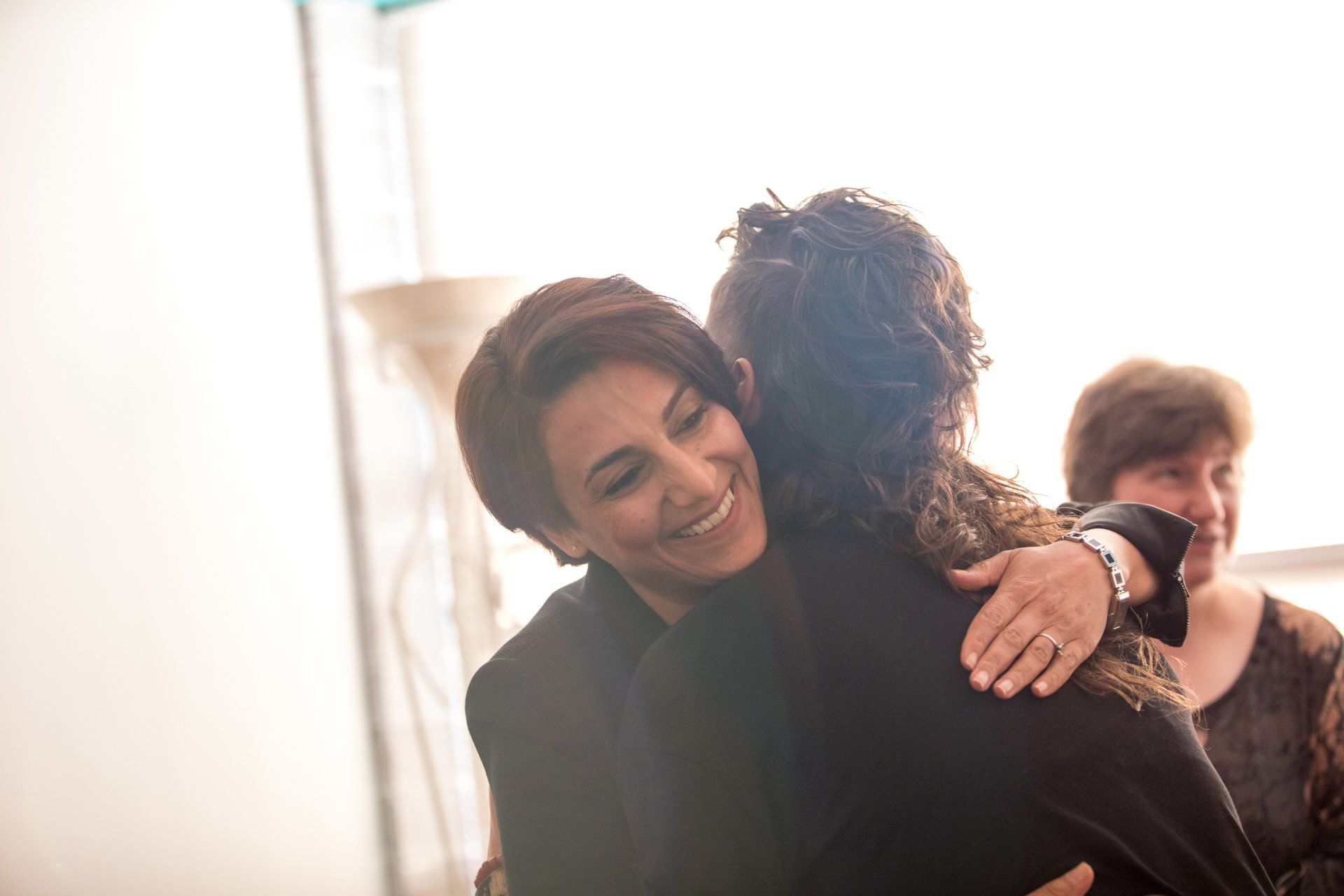 A person is hugging another person in a room.