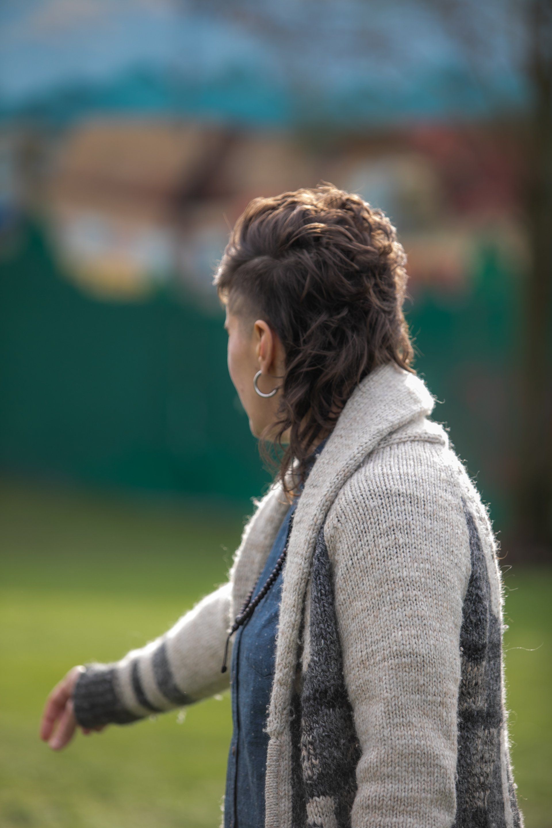 A person in a sweater is walking in a field.