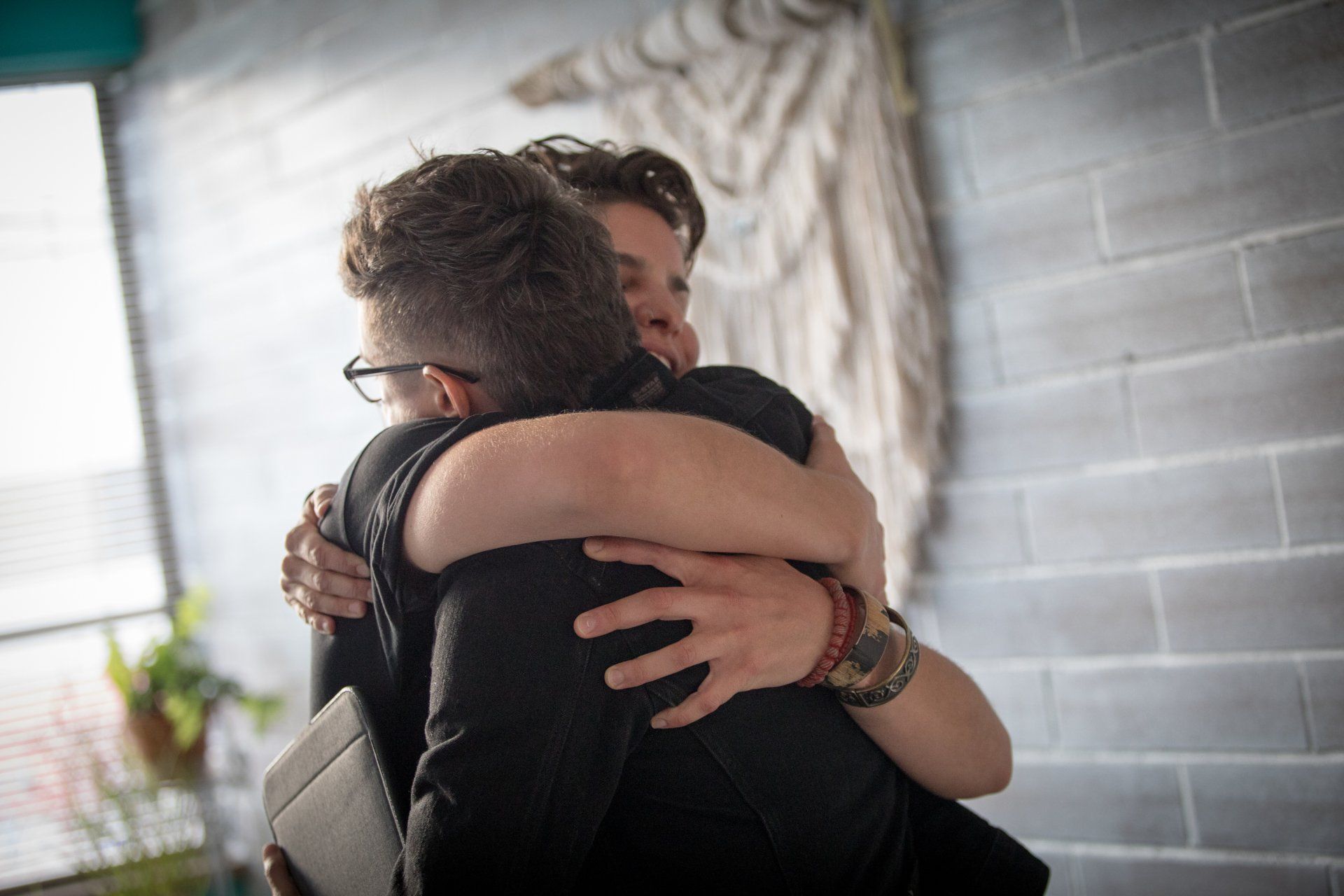 Two persons are hugging each other in a room.