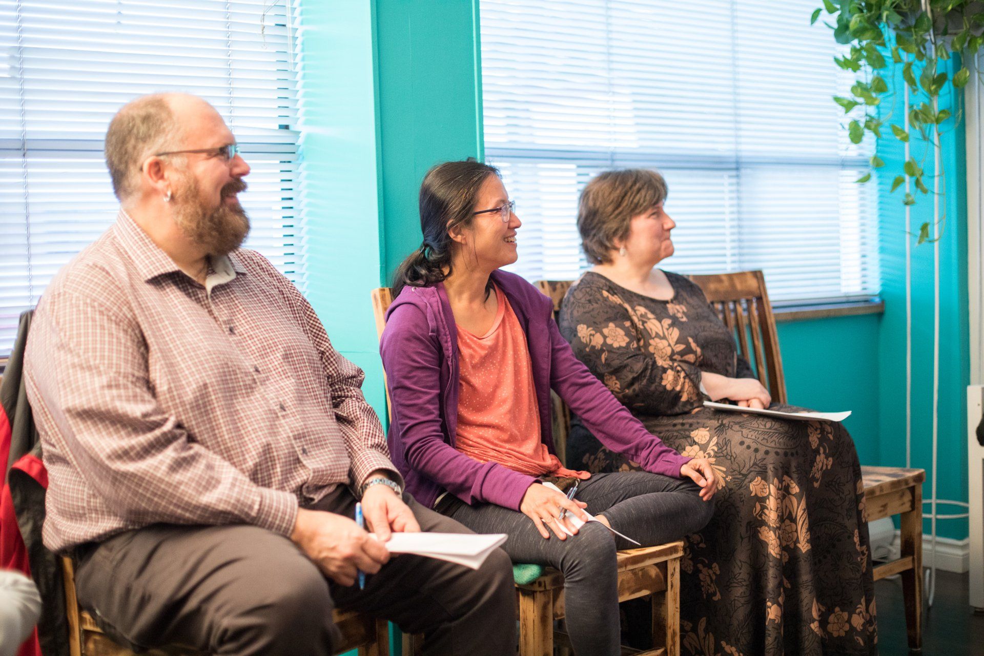 A group of people are sitting in chairs in a room.