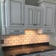 White kitchen cabinets with black distressing.