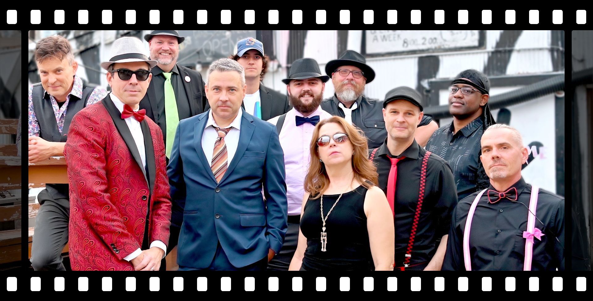 A group of people posing for a picture in front of a bauhaus sign