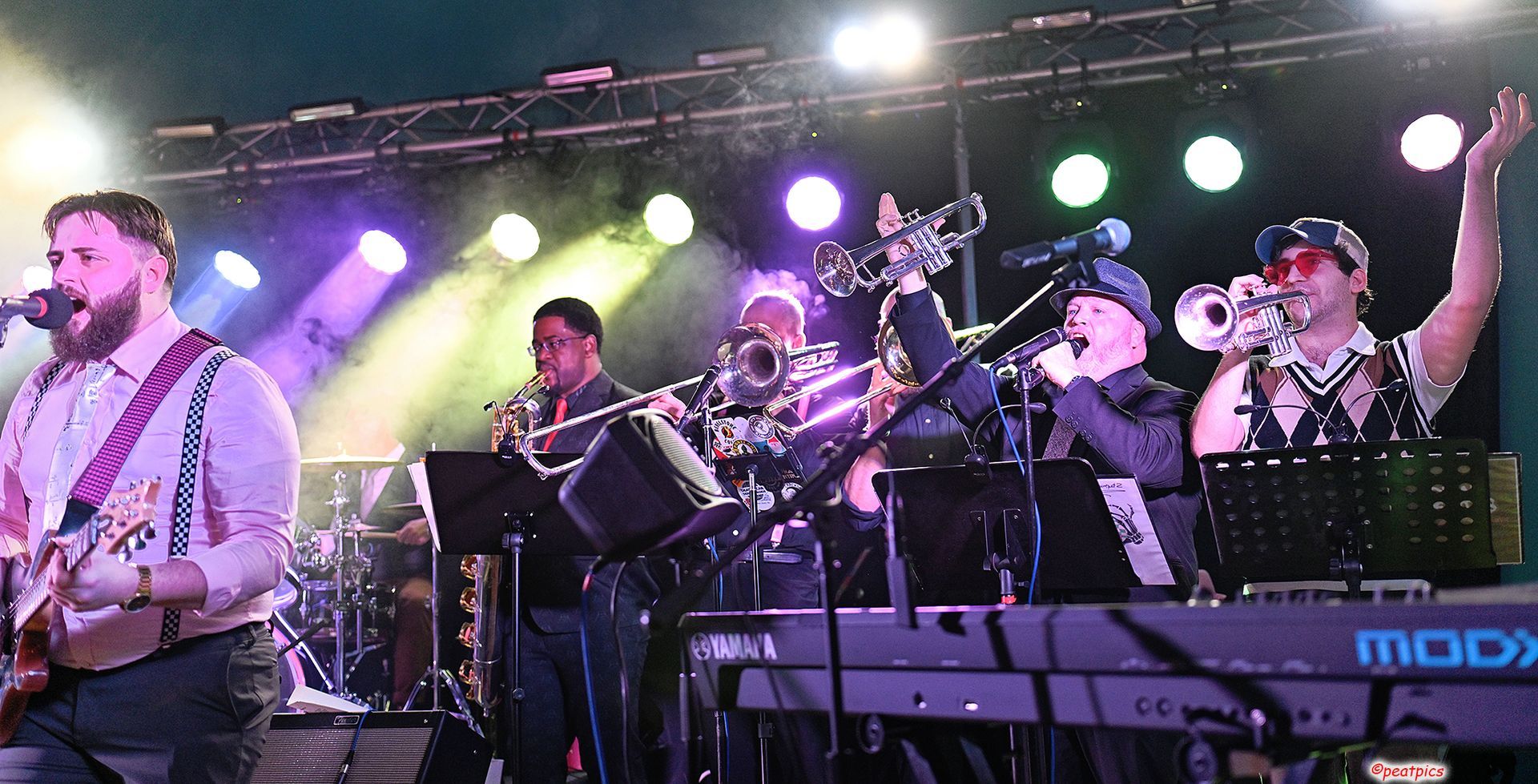 A group of men are playing instruments on a stage at a Dead Bettys show.