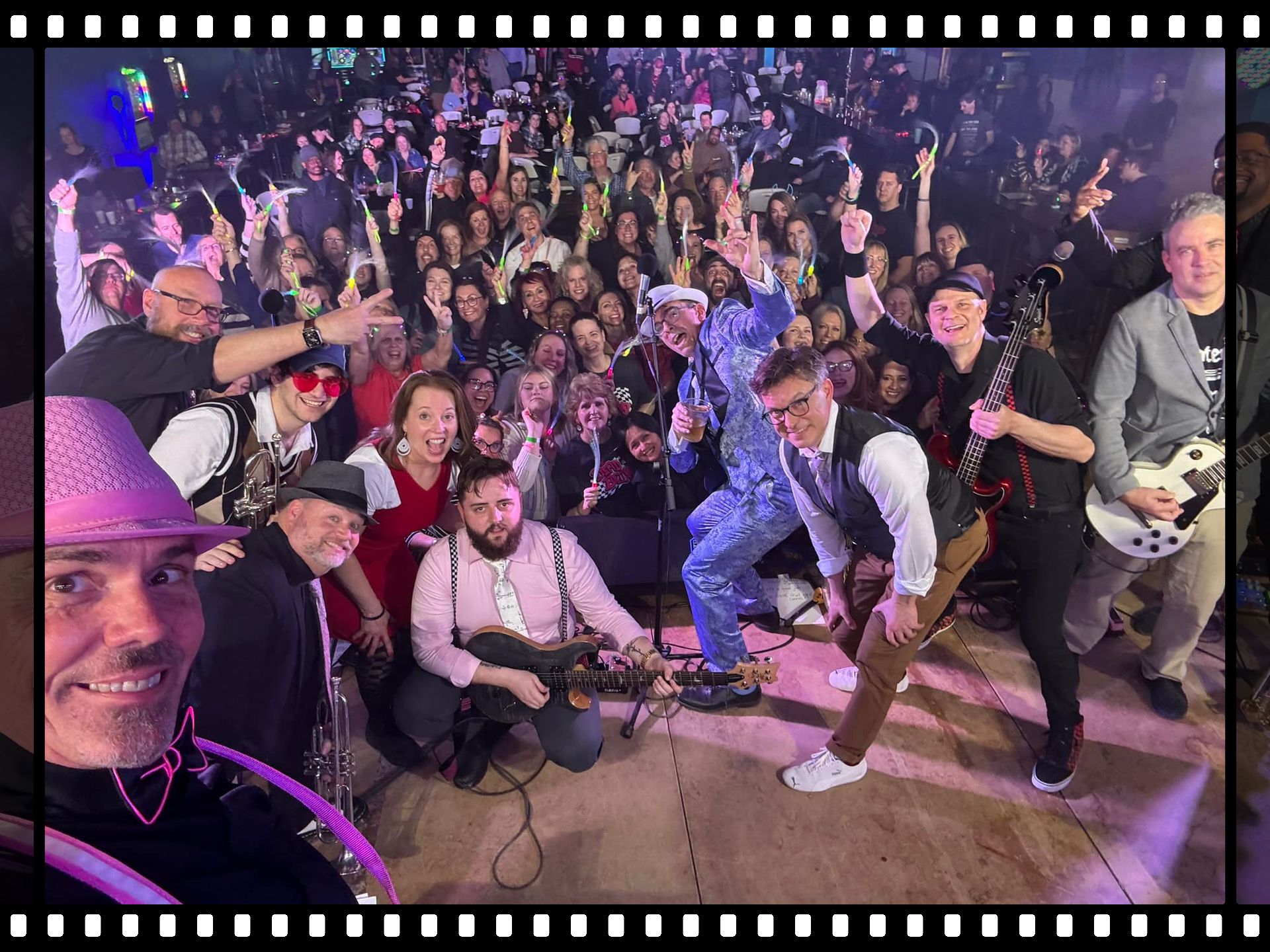 A group of people are posing for a picture in front of a crowd at a Dead Bettys show.