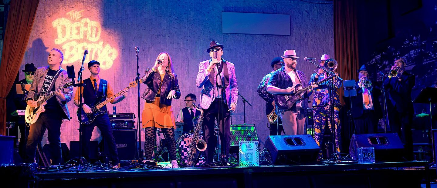 A group of men are playing guitars on a stage
