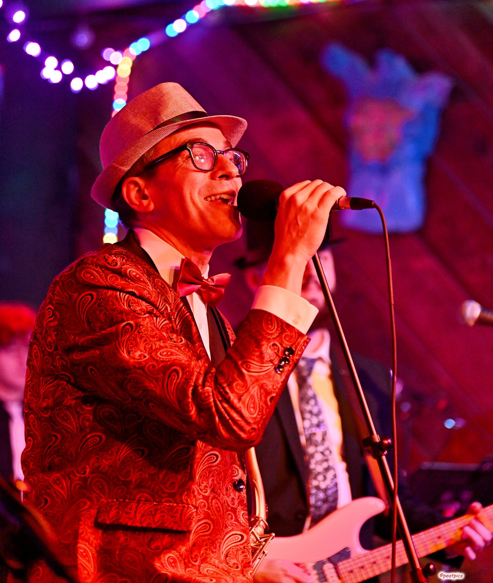 A man in a red suit singing into a microphone