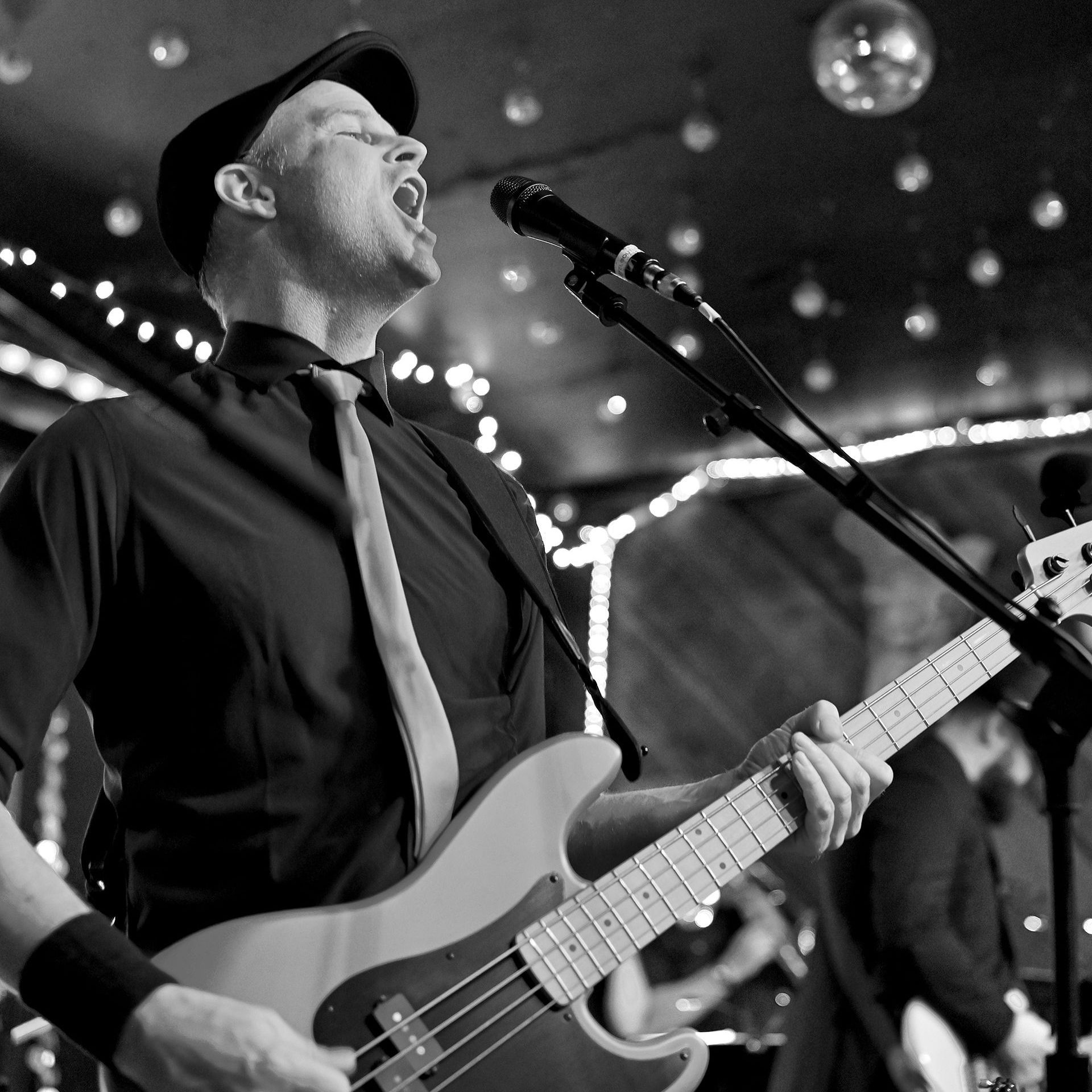A man singing into a microphone while playing a guitar