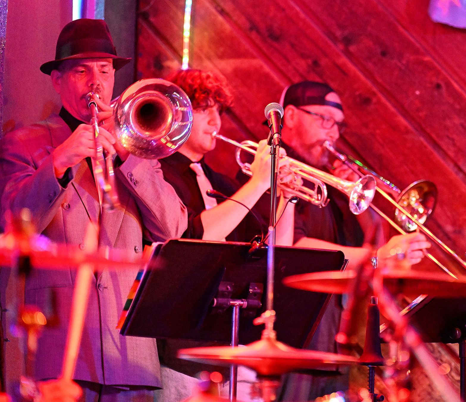 A man in a hat is playing a trumpet in a band