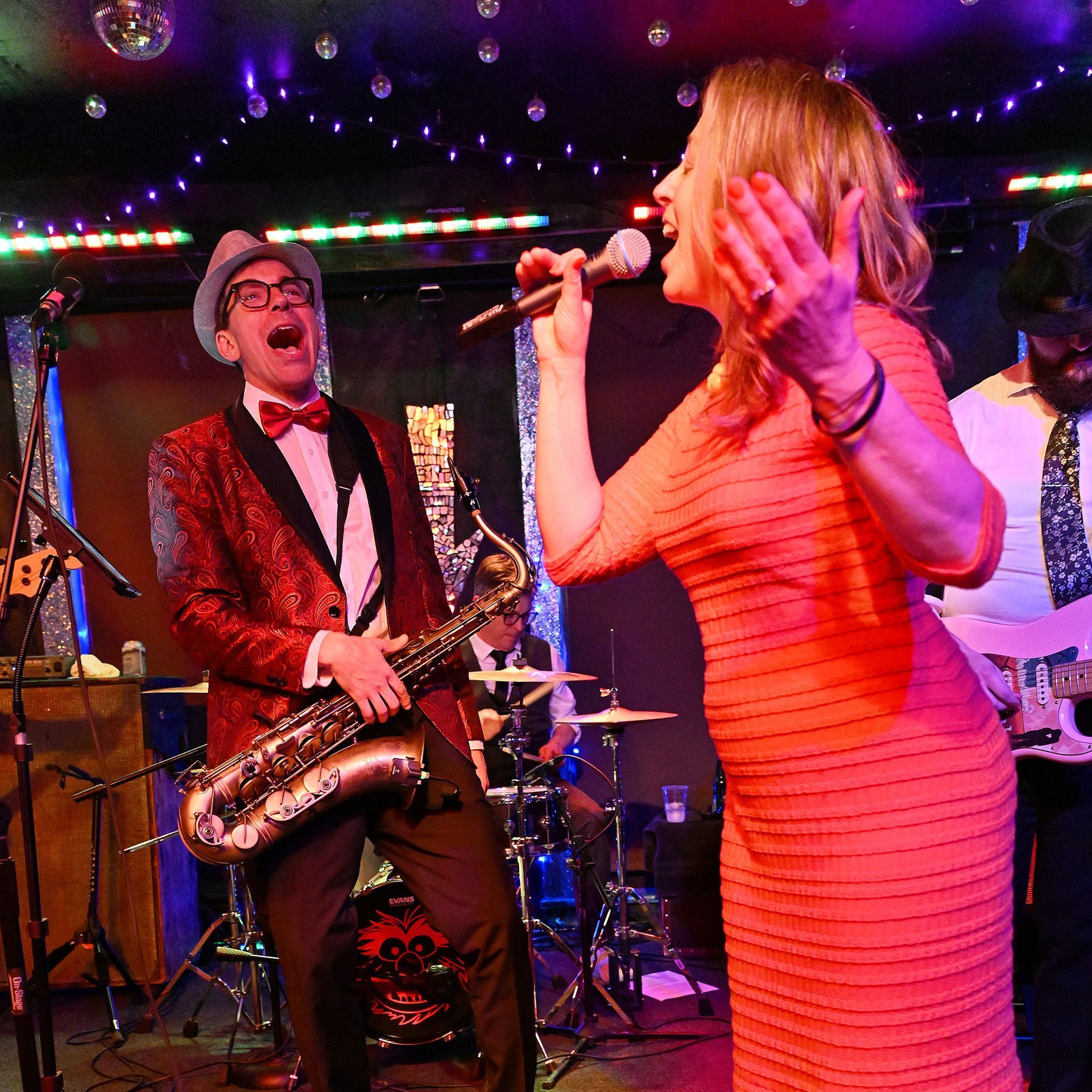 A man playing a saxophone and a woman singing into a microphone