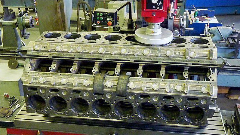 a large engine block is being worked on by a machine