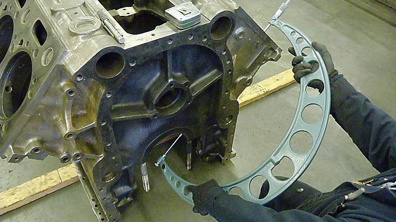 a man is measuring a piece of metal with a micrometer