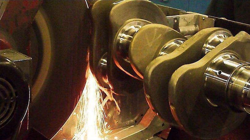 a close up of a machine grinding a crankshaft