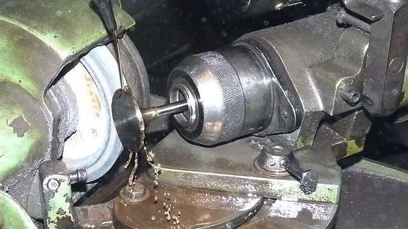 a drill bit is being sharpened on a machine .