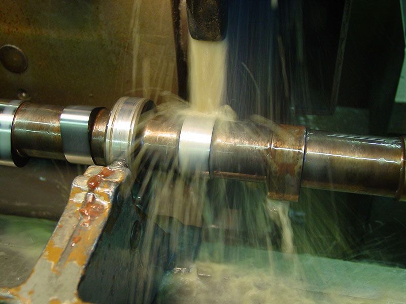 a machine is cutting a piece of metal with liquid coming out of it .