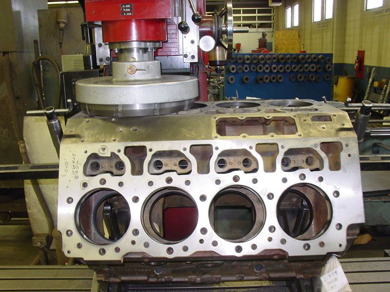 a machine is working on a cylinder block in a factory