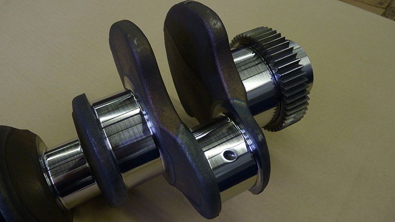 A close up of a crankshaft on a table at our engine machine shop in Edmonton.