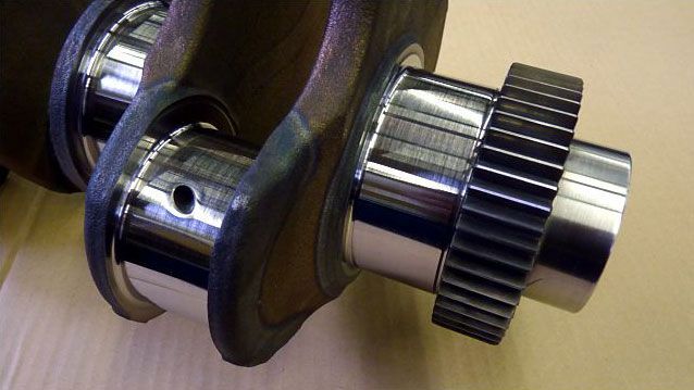 a close up of a crankshaft with a gear attached to it