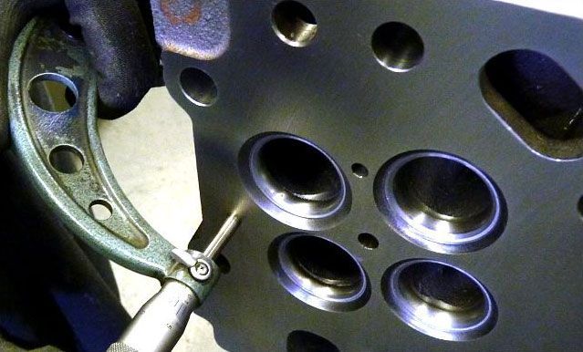 a person is measuring a piece of metal with a micrometer