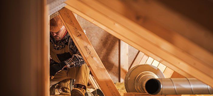 A man is working in the attic of a house.