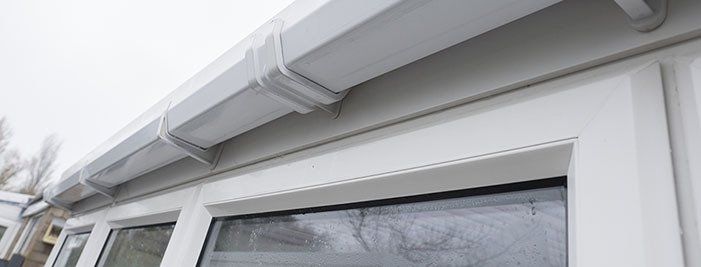 A close up of a window and gutter on a house.