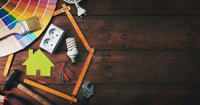 A wooden table topped with a bunch of tools and a house.