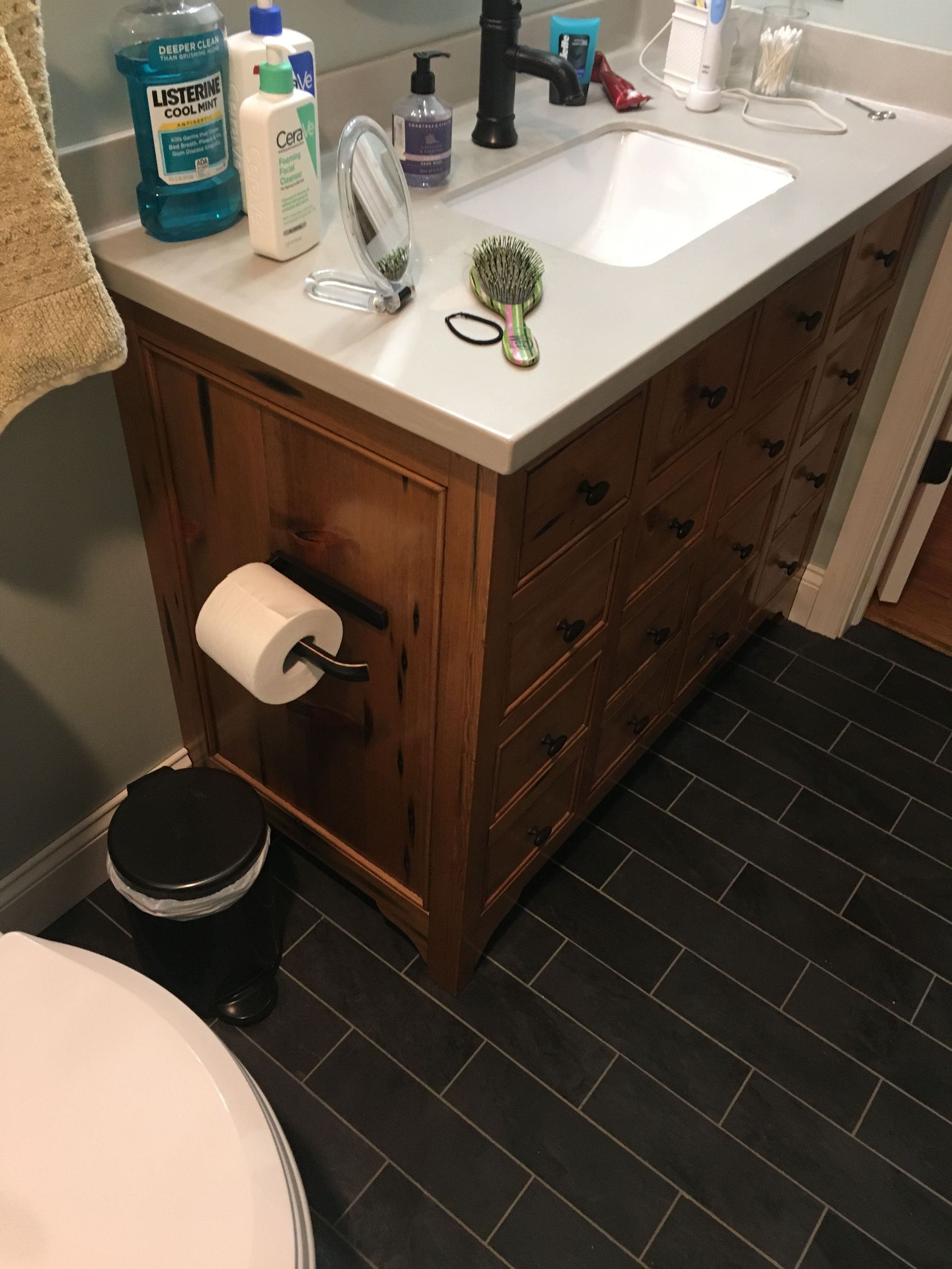 A bathroom with a sink, toilet and trash can