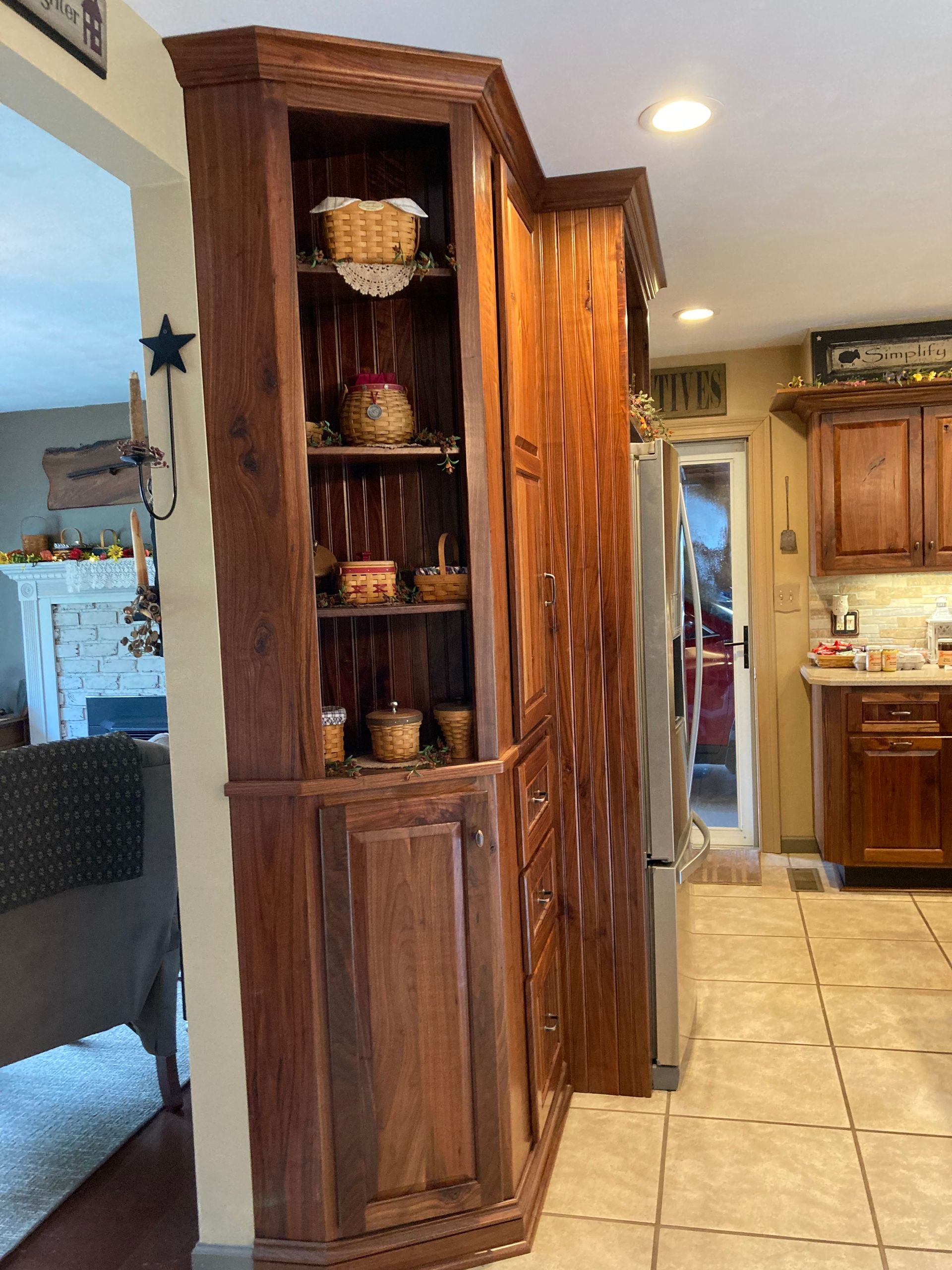 A kitchen with wooden cabinets and a stainless steel refrigerator