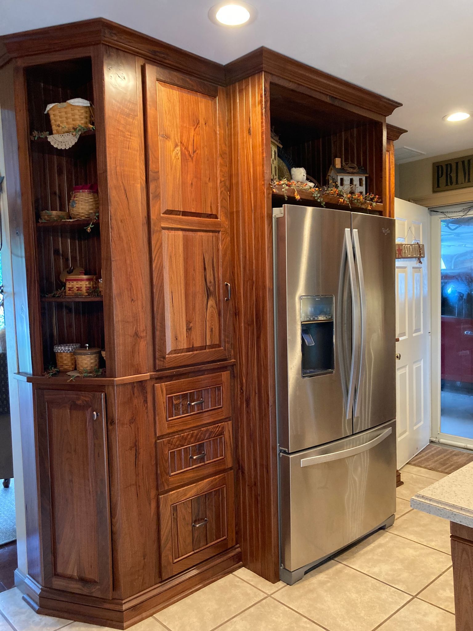 A kitchen with wooden cabinets and a stainless steel refrigerator.