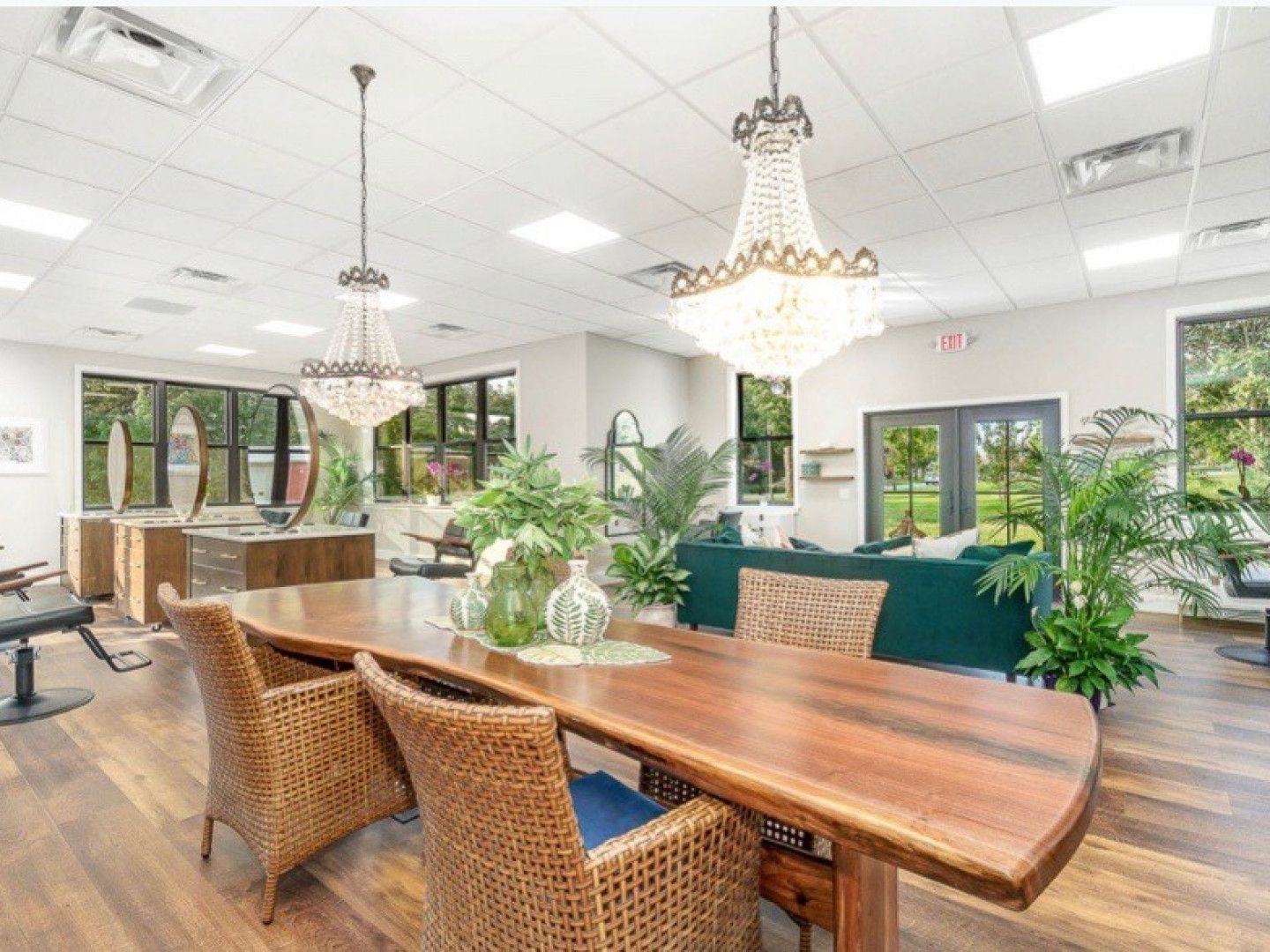 A living room with a table and chairs and a chandelier hanging from the ceiling.