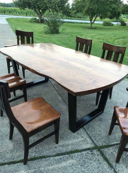 A wooden table and chairs are sitting on a sidewalk