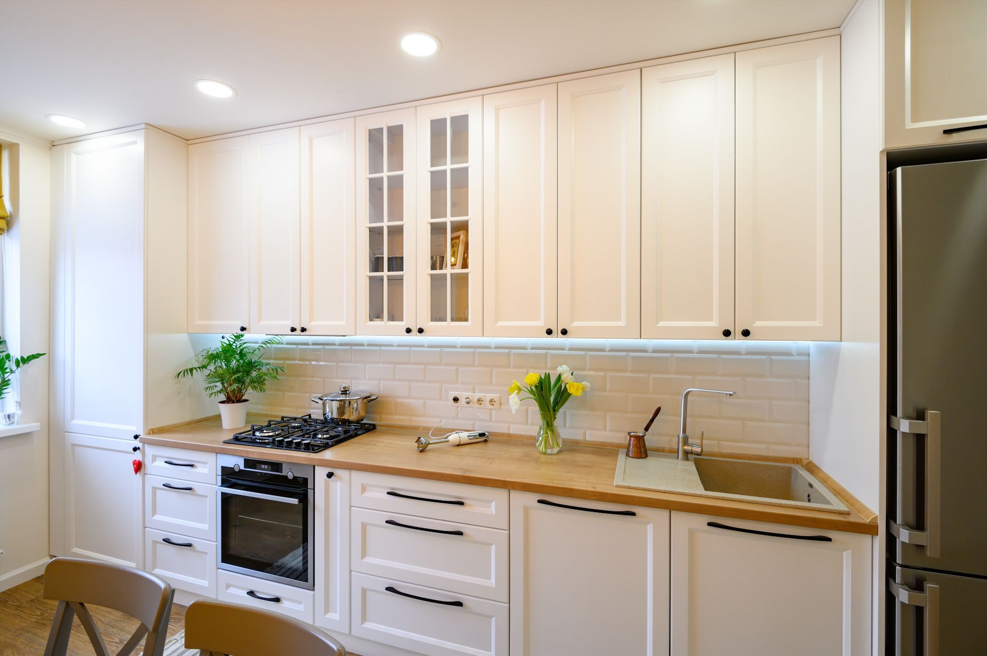 A kitchen with white cabinets, a stove, and a sink.