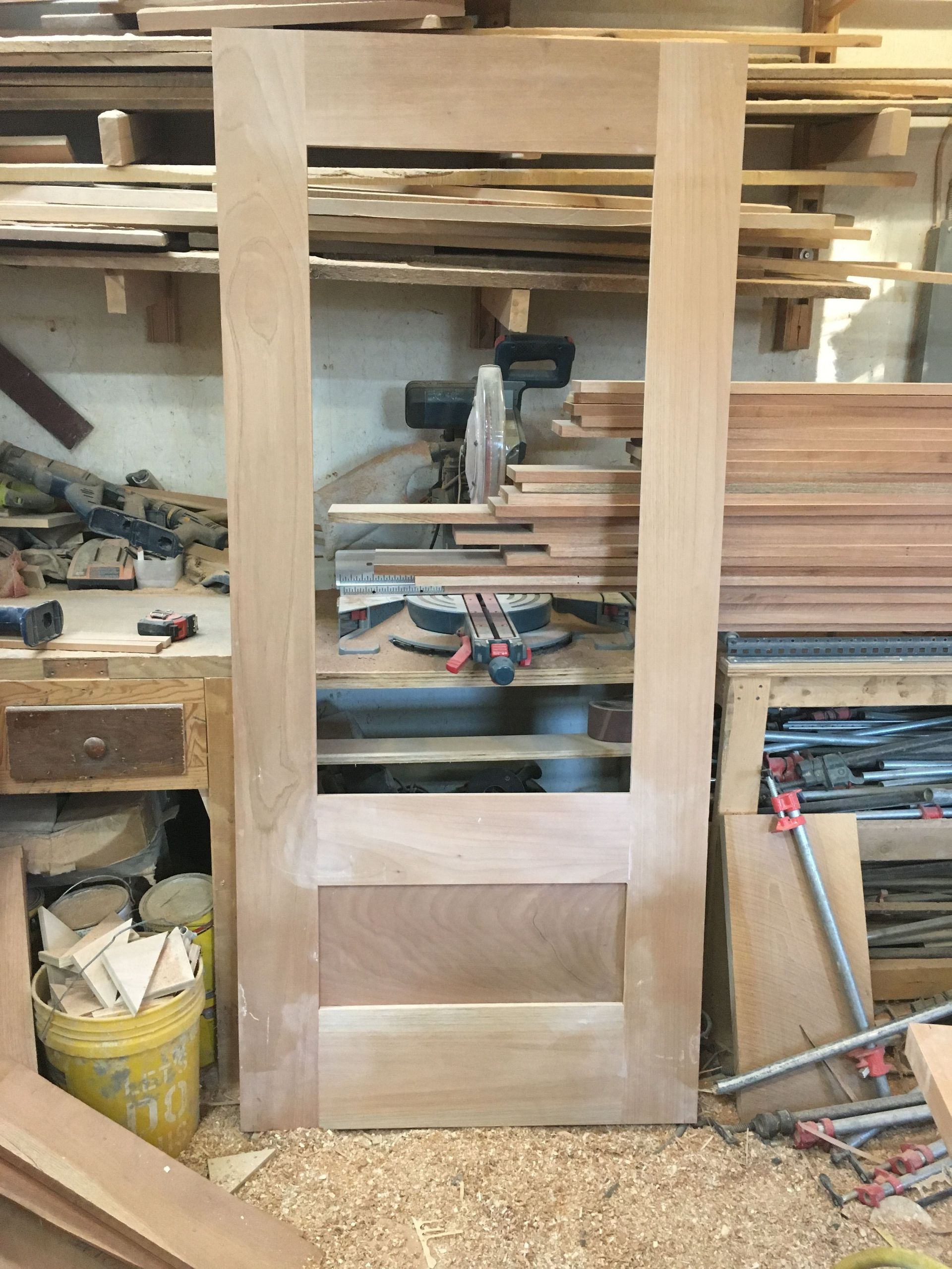 A wooden door is being built in a workshop.