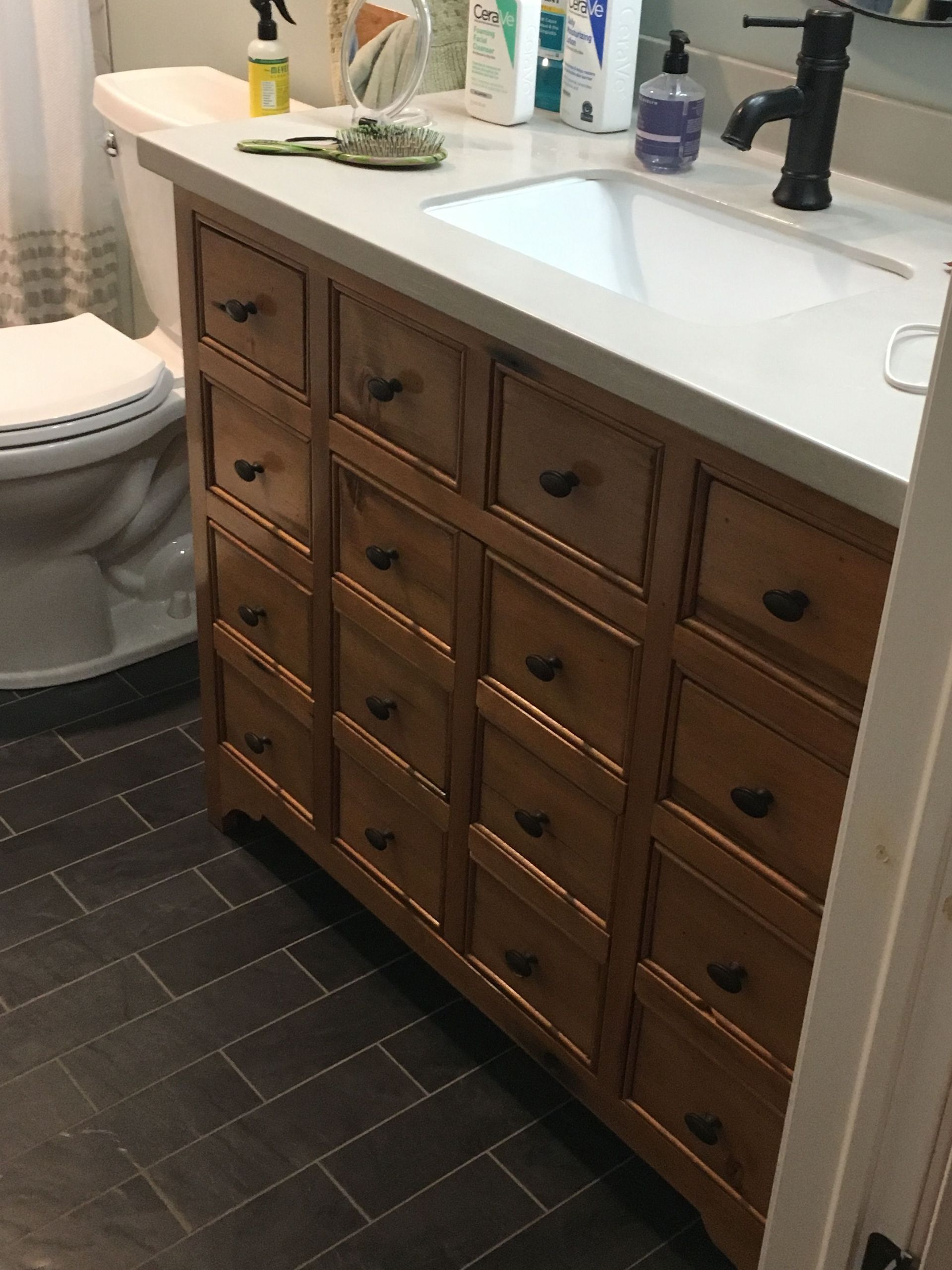 A bathroom with a toilet, sink and drawers