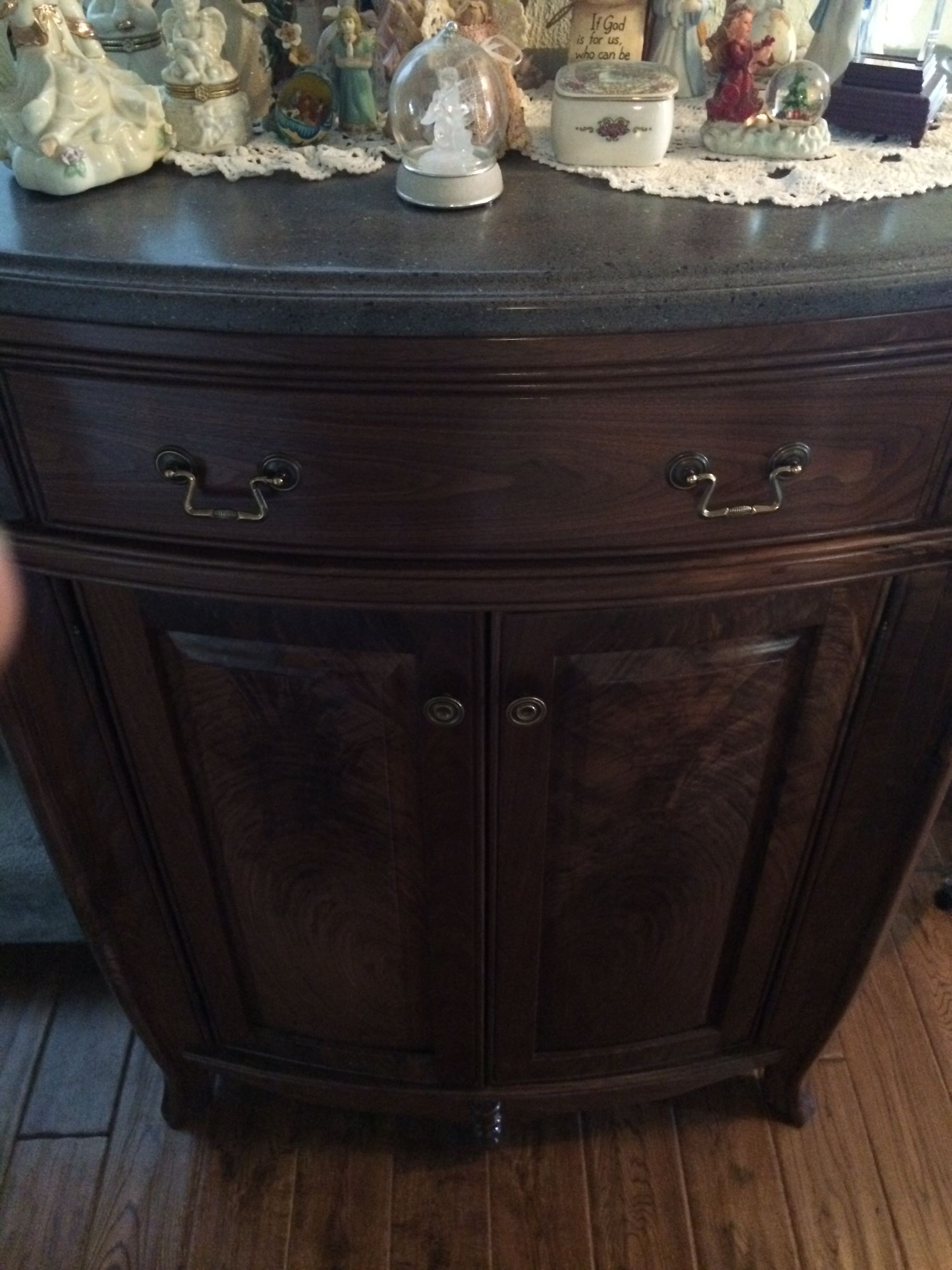A wooden cabinet with drawers and doors is sitting on a wooden floor.