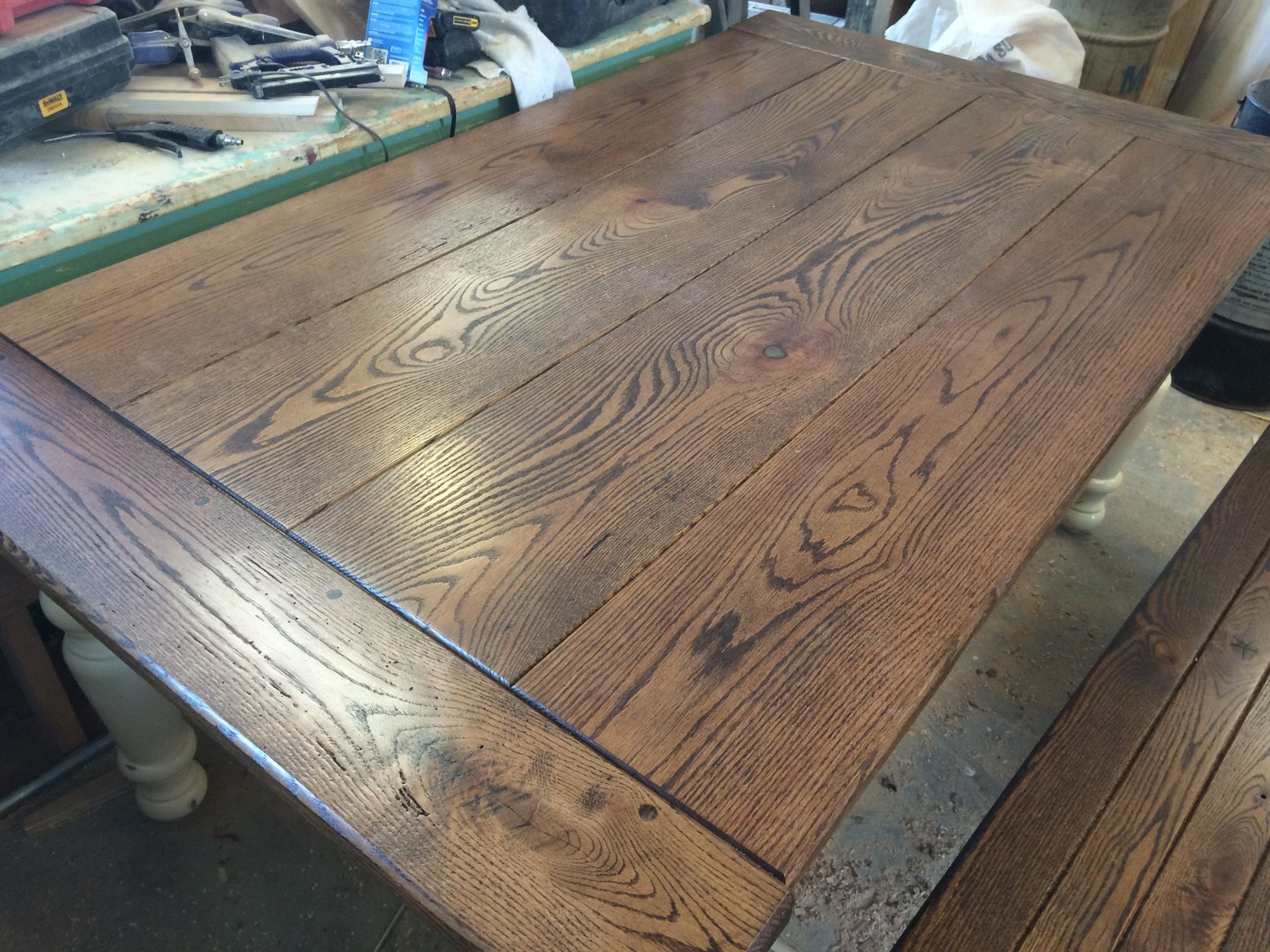A wooden table with a bench underneath it in a room.