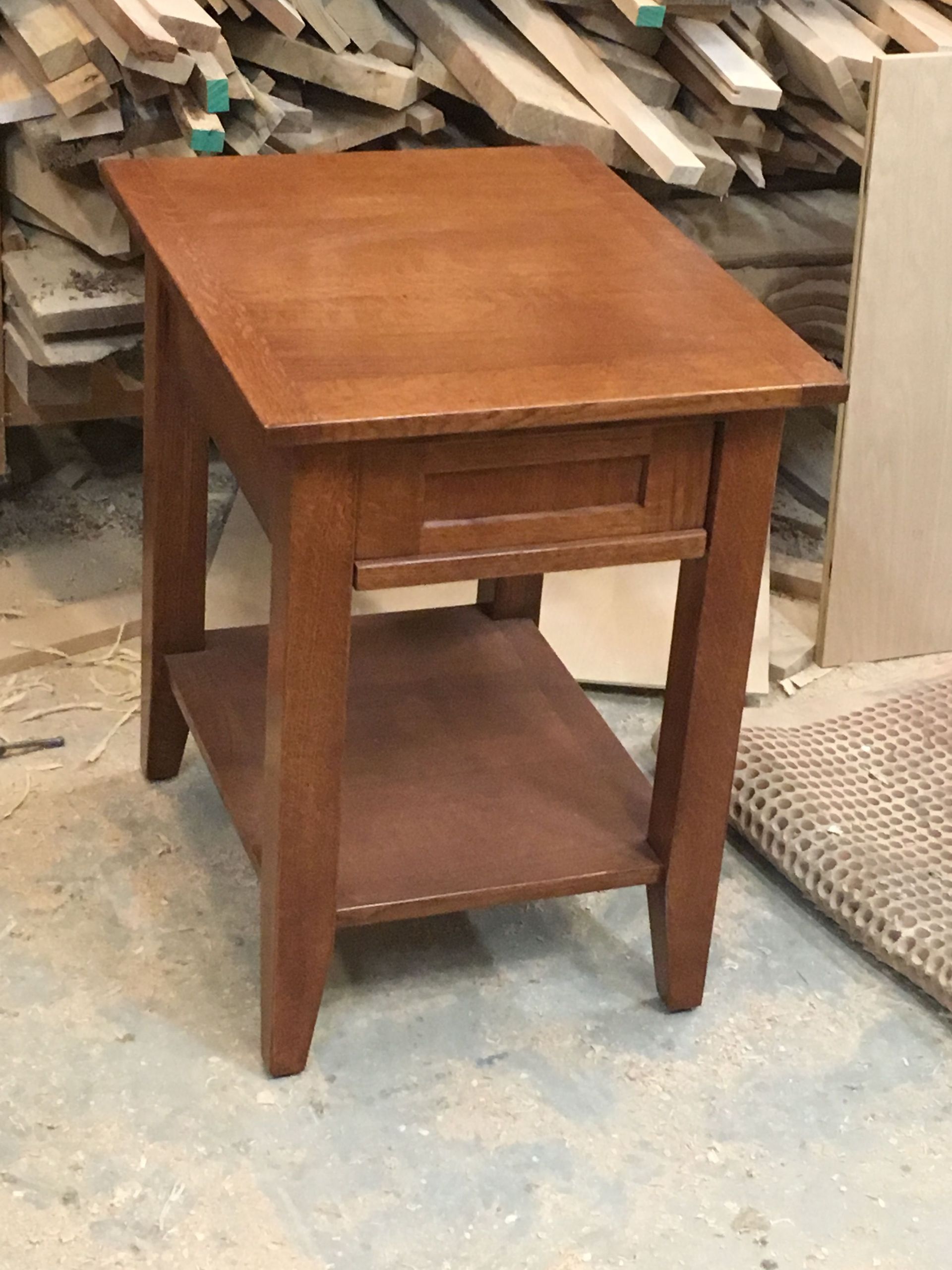 A small wooden table with a drawer underneath it