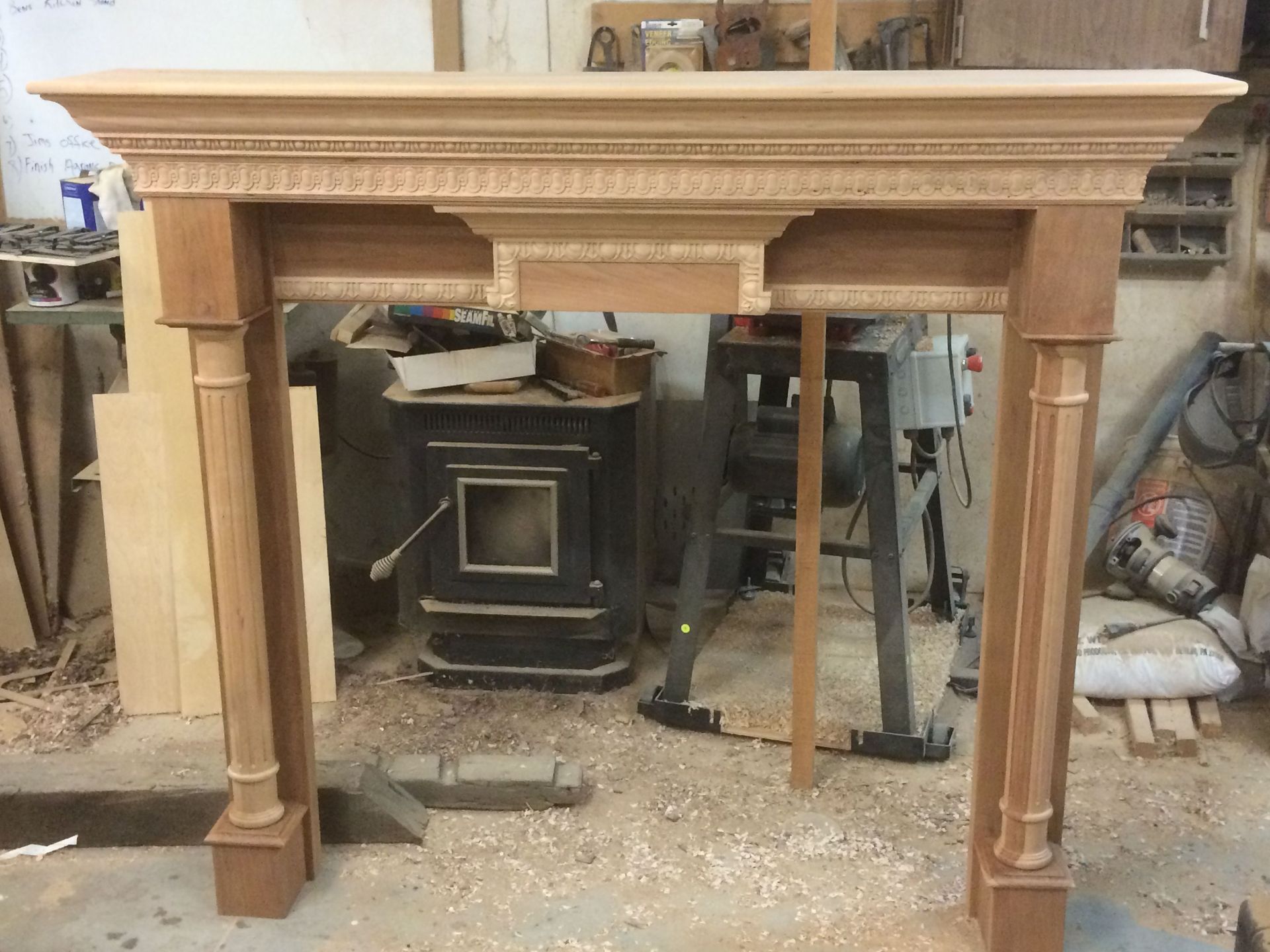 A wooden fireplace mantle is being built in a workshop