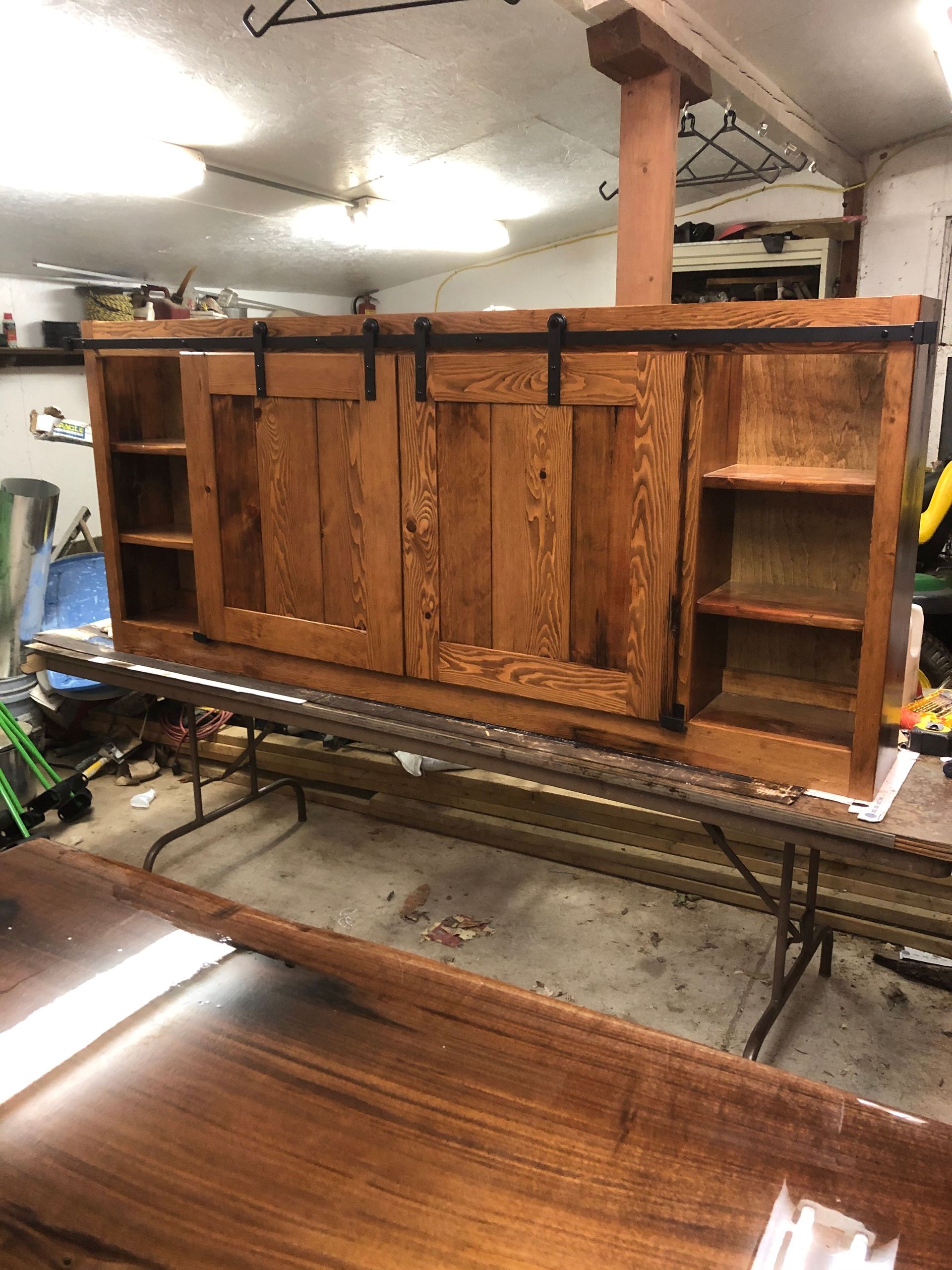 A wooden cabinet with sliding doors is sitting on top of a table.