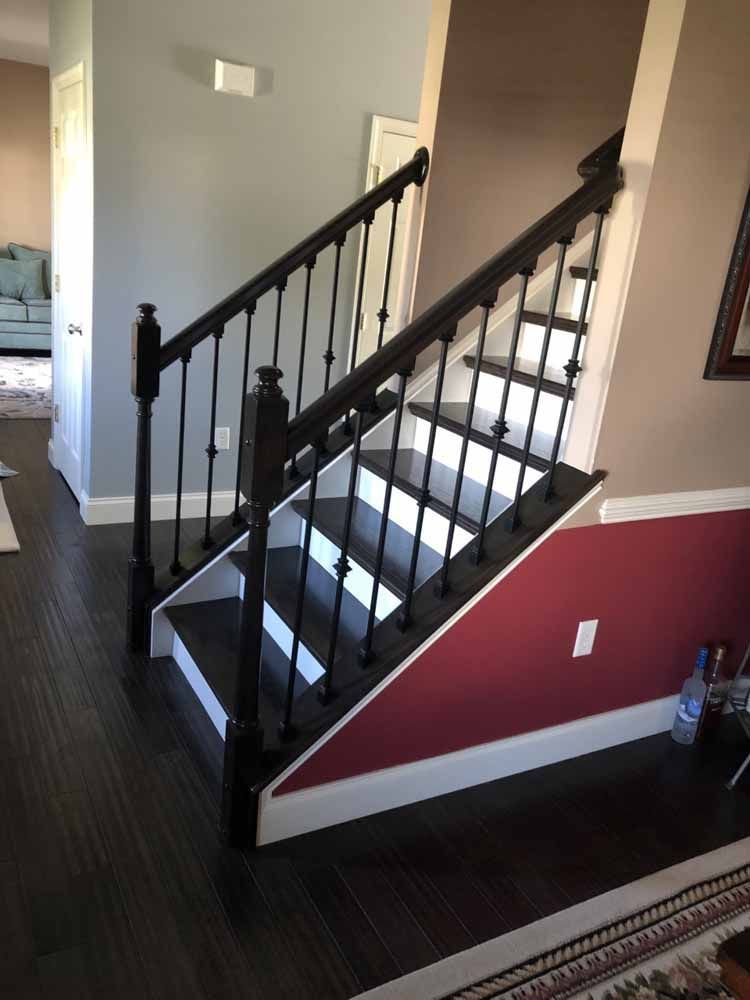 A staircase with a black railing in a living room