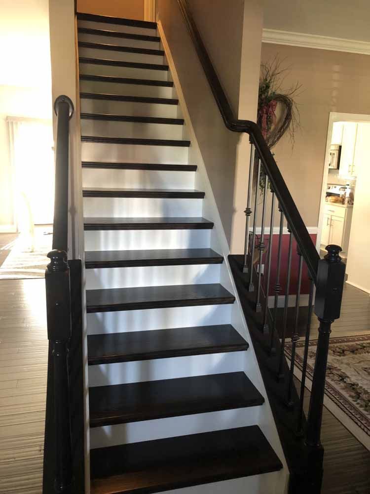 A staircase with black and white steps and a black railing