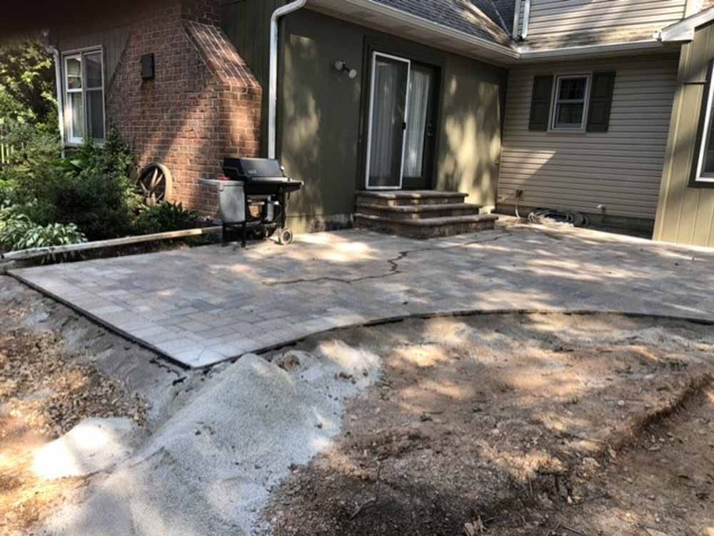 A patio is being built in front of a house.