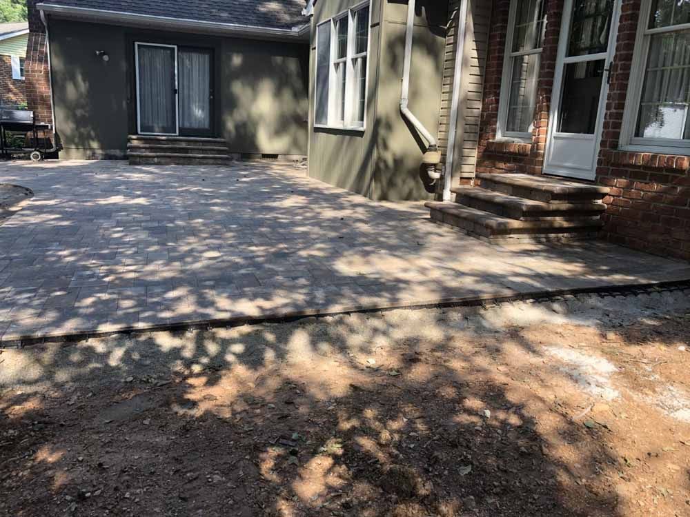 A brick house with a patio in front of it.