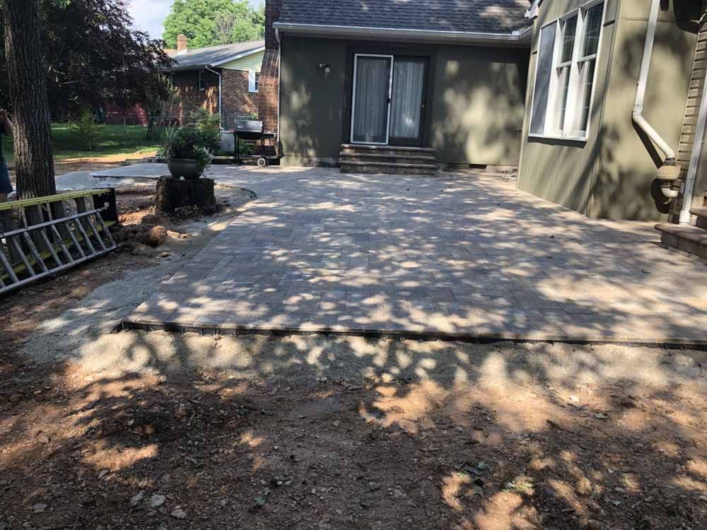 A patio is being built in front of a house.