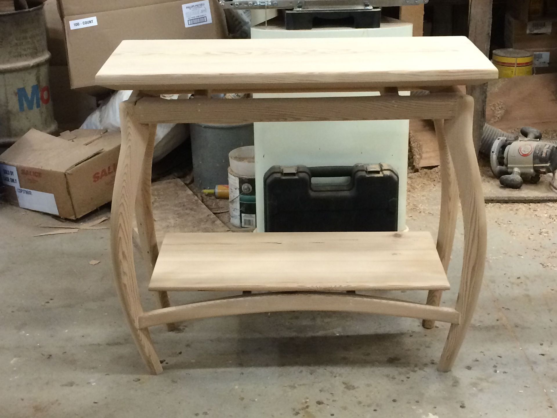 A small wooden table with a shelf underneath it