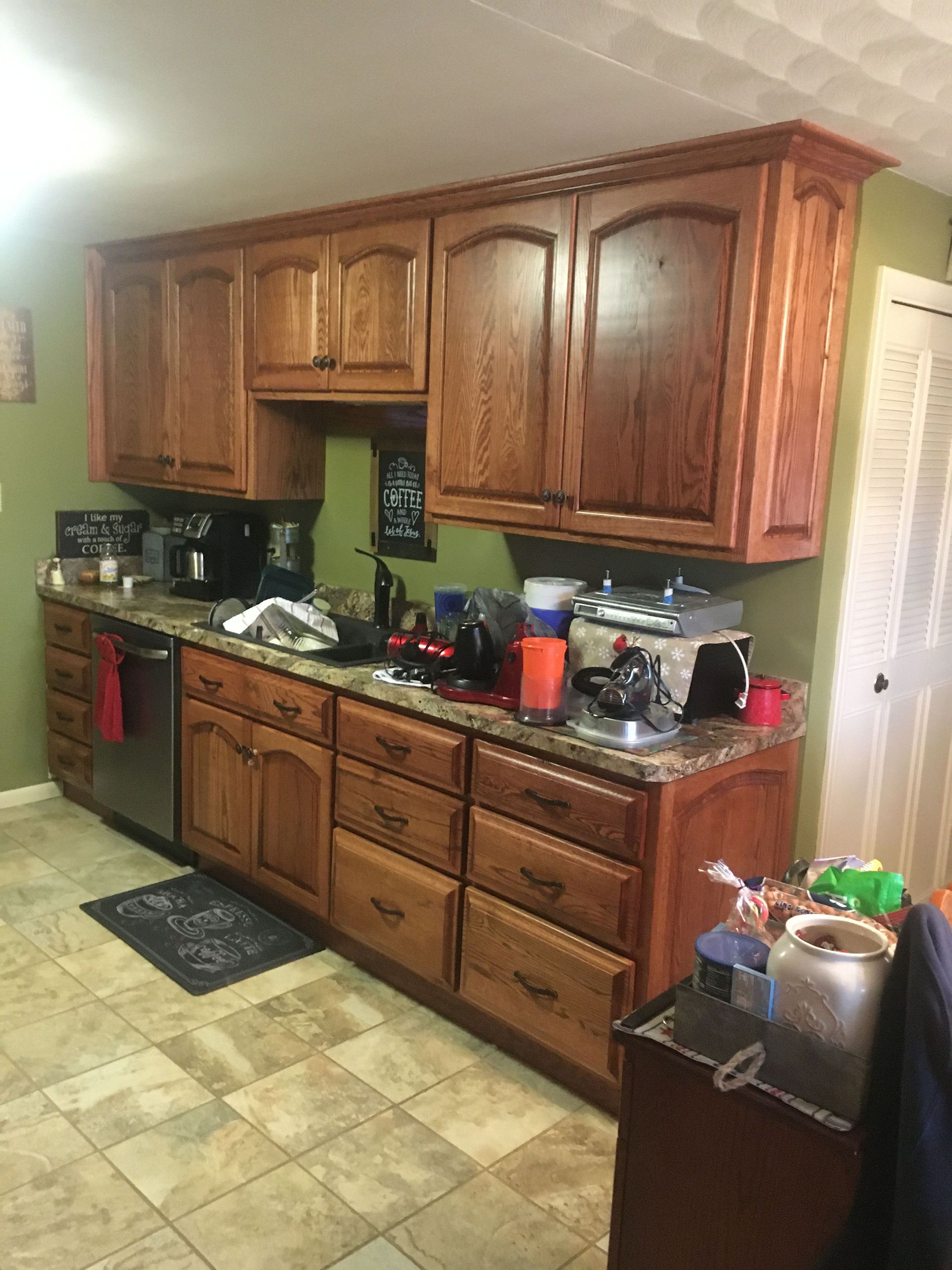 A kitchen with wooden cabinets , granite counter tops , and stainless steel appliances.