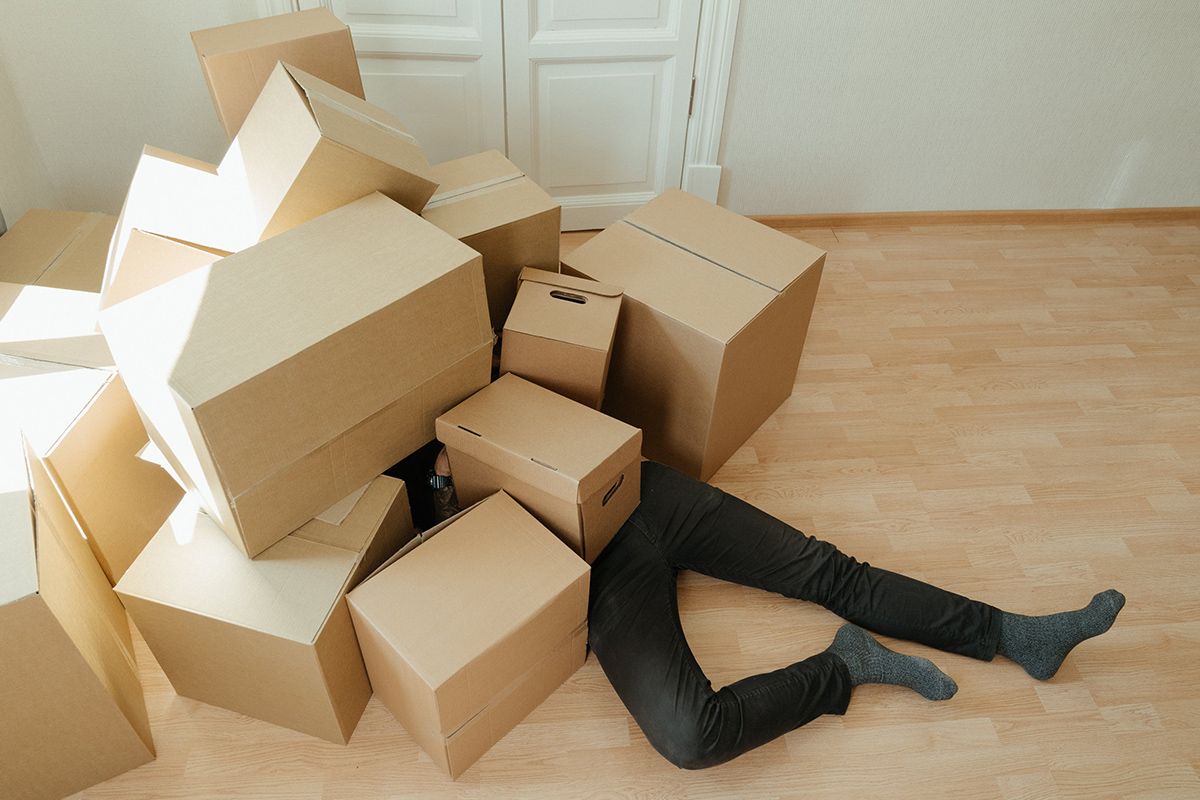 a person laying on the floor surrounded by cardboard boxes